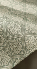 Aufkleber - Close-up of sage green fabric with embossed floral pattern, showcasing intricate detail and texture, ideal for textile or design background