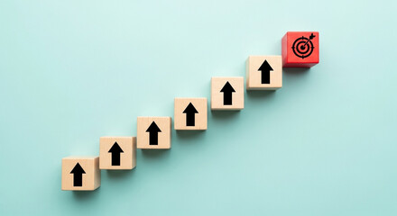 Poster - Wooden blocks with arrows pointing up and a target block on a light blue background representing growth