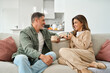 © insta_photos - Happy middle aged mature couple talking relaxing on couch at home. Relaxed smiling older man and woman in love sitting on sofa together enjoying tea and conversation in modern house living room.