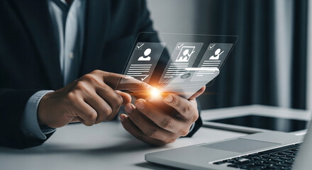 Poster - Man in suit holding transparent phone with candidate profiles and laptop on desk nearby