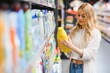 © Serhii - Young glad smiling woman buying household chemicals or laundry detergent at supermarket