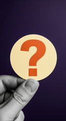 Poster - Hand holds round beige card with orange question mark, symbolizing inquiry, uncertainty, or need for information, suitable for FAQ pages or problem-solving concepts