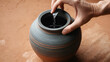 © John - A hand holds a clay jar and pours water