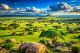 African savanna landscape with acacia trees, granite boulders, and vibrant green grass under a sunny sky