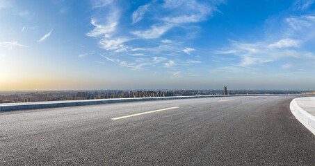 Wall Mural - empty asphalt highway road and city skyline with residential area buildings under blue sky