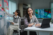 © PaeGAG - Businesswoman smiling and working with tablet while colleague analyzing financial charts