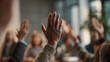 © Daniel - A politician addressing community issues during a town hall meeting with local residents raising hands for questions.