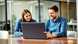 © Masuda Begum - Smiling coworkers collaborating on laptop in modern office
