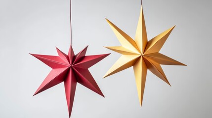 Poster - Two hanging paper stars, red and gold, against a white background.