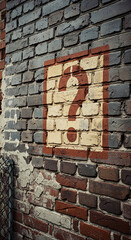 Poster - Brick wall texture with painted question mark, representing uncertainty, inquiry, or a need for answers, suitable for various concepts