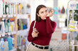 © JackF - Young woman buyer testing perfume in household chemicals store