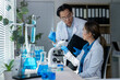 © Wasana - Scientists working with microscope and test tubes doing scientific research in laboratory