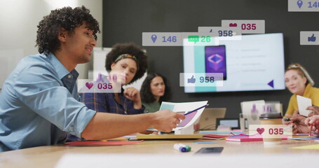 Poster - Discussing office-attired team reviewing documents on table in meeting room with social media icons