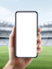 Poster - Hand holding blank vertical smartphone screen with blurred stadium background, creating focused and modern digital display