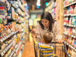 © Apichat - woman is pushing a shopping cart with a baby in it