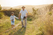 © prostooleh - Photo of a little boy with his grandfather walking in a field at summer