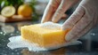 © Lestari_Suti - Close-up of gloved hands cleaning a kitchen surface with soapy sponge