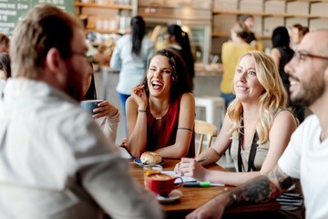 Leinwandbilder - Diverse group of people socializing conversation in cafe. Group of smiling and laughing people with friend and friendly interaction. Mixed genders and ethnicities people socializing in cafe