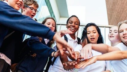Poster - Group of diverse students in school uniforms, hands together in teamwork. Smiling teens, diverse group, school spirit, teamwork, unity, diverse students. Diverse students in team at school.