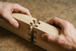 © newlifestock - Wooden joint connection with hands holding two pieces of wood demonstrating sustainable engineering work in carpentry and woodworking craft