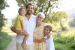 © Halfpoint - A portrait of young family with small children in sunny summer nature.