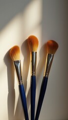 Poster - Three makeup brushes on a minimalist tabletop during daytime