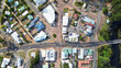 © Sam Jeffs - Top down Arial view of a small rural town centre with cars on the road, roof tops of homes and businesses, a river with park and trees. Main road with 4 Way intersection. Denmark Western Australia