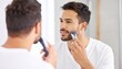 © ruangrit19 - Man Trimming Beard in Bathroom Mirror Morning Routine.