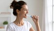© Kim de Been - Woman Brushing Teeth in Bright Modern Bathroom – Personal Hygiene and Wellness Routine