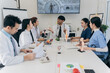 © ArLawKa - Doctors are talking casually on laptops to prepare for treatment and are having a meeting in the office. The medical team is talking and working together in the hospital.