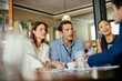 © Marko Geber - Diverse group of coworkers from a business company having a meeting in a cafe bar in the city