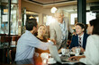© Marko Geber - Group of business people having a meeting in a cafe bar