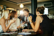 © Marko Geber - Diverse group of business people and coworkers having a meeting after work and enjoying a glass of wine in a cafe bar