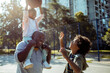© Davor - African American family playing basketball outdoors with a little girl learning to shoot