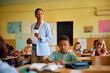 © Drazen - Black teacher and her students during test in classroom.