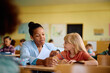 © Drazen - Black female teacher assisting schoolgirl during class at elementary school.