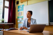 © Drazen - Black elementary school teacher at her desk in classroom.