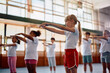 © Drazen - Schoolgirl and her classmates warming up during physical education class.