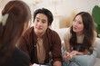 © eggeeggjiew - Young Asian Couple in relationship therapy with female psychologist, seated close in emotional talk.
