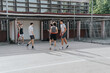 © qunica.com - Friends gather for a casual basketball game on an old neighborhood court, highlighting camaraderie and outdoor fun in a nostalgic urban environment.