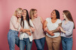 © Maria Vitkovska - Five diverse women embracing and laughing together on pink background