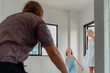 © VStudio - Candid moment of a family playing joyfully in the empty, spacious room of their new house. Daughter running towards her father in a game of hide and seek after moving into a new home.
