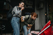 © qunica.com - Two women with backpacks enjoy snacks outside while admiring a baby in a red stroller. Urban setting conveys a casual, friendly atmosphere.
