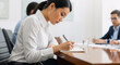 © Aleksandr_79 - Female executive writing in document during conference.
