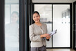 © jojo - Businesswoman holding file, standing in office