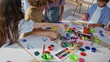 © stockbusters - Creative school children painting at art lesson on classroom desk. Group pupils