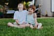 © SHOTPRIME STUDIO - Happy children playing together on a sunny lawn, showcasing joy and friendship in a vibrant outdoor setting with green grass.