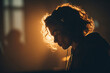 © barmaleeva - Silhouette of person with headphones in warm backlight and moody setting