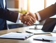 © KALOKI - Accord professionnel entre deux collègues dans un bureau moderne – poignée de main et contrat signé