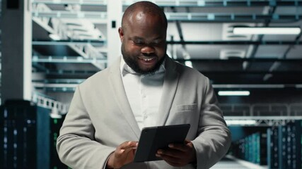 Poster - Close up of technician walking in data center, using tablet to check equipment for system stability. IT expert overseeing server farm, using device to configure rigs, optimizing performance, camera B
